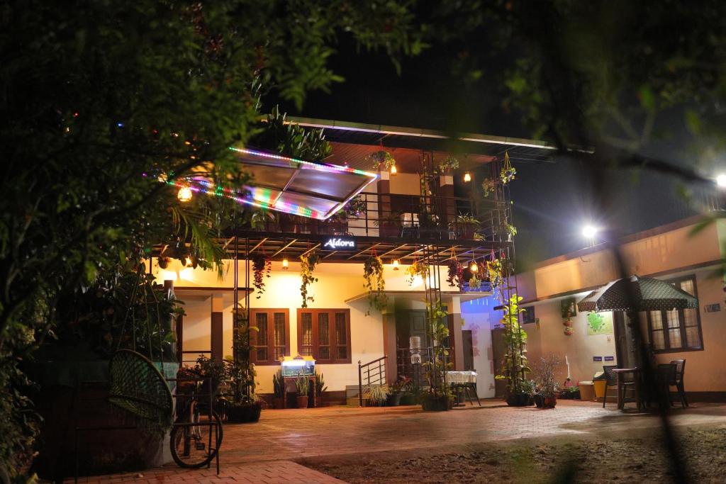 a building with a balcony at night at Aldora Holiday Homes in Vythiri