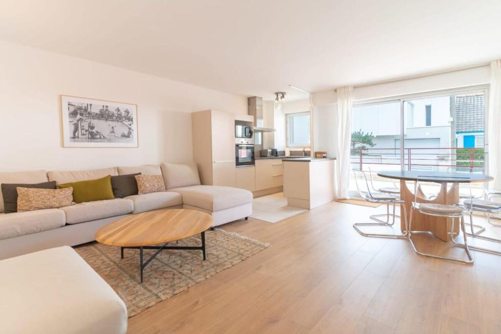 un soggiorno con divano e tavolo di Magnificent town-centre apartment with two terraces 5 people a Le Touquet-Paris-Plage