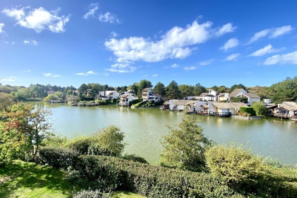 einen Fluss mit Häusern an der Seite in der Unterkunft Superb duplex with lake view for 6 people in Le Touquet-Paris-Plage