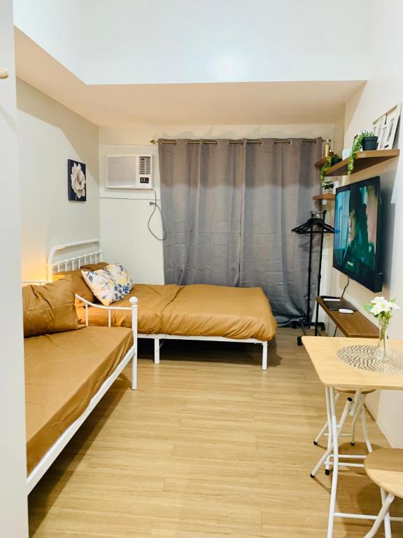 a living room with two beds and a table at EZ Cityscape Studio at Loop Towers Limketkai in Cagayan de Oro