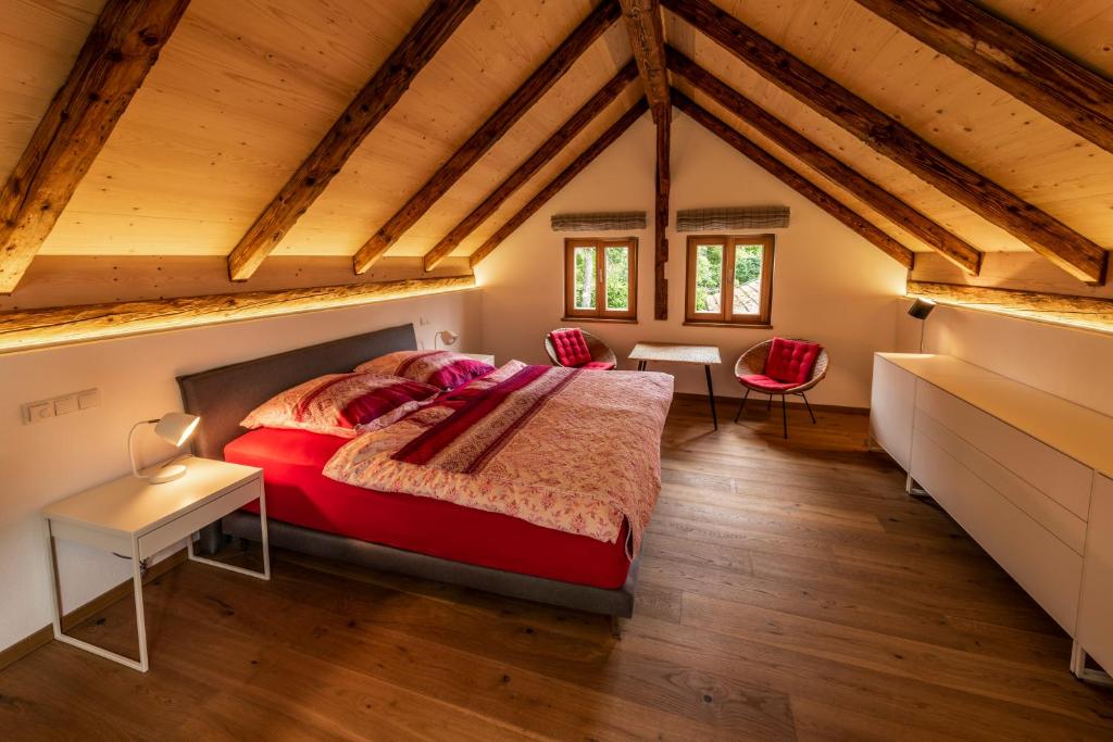 a bedroom with a red bed in a attic at Ferienhaus am Park in Grafenau