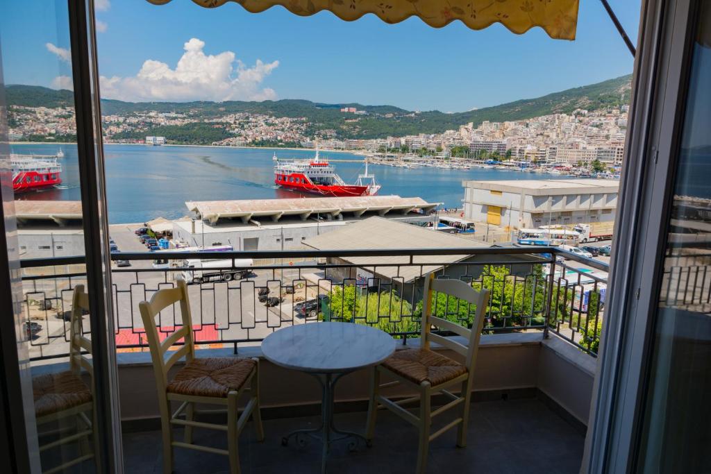 a balcony with a table and chairs and a view of a harbor at Kalimera Apartment in Kavála