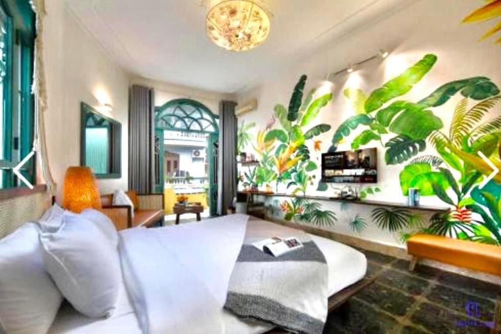 a living room with a white couch and plants on the wall at Nemohousehomestay in Hanoi