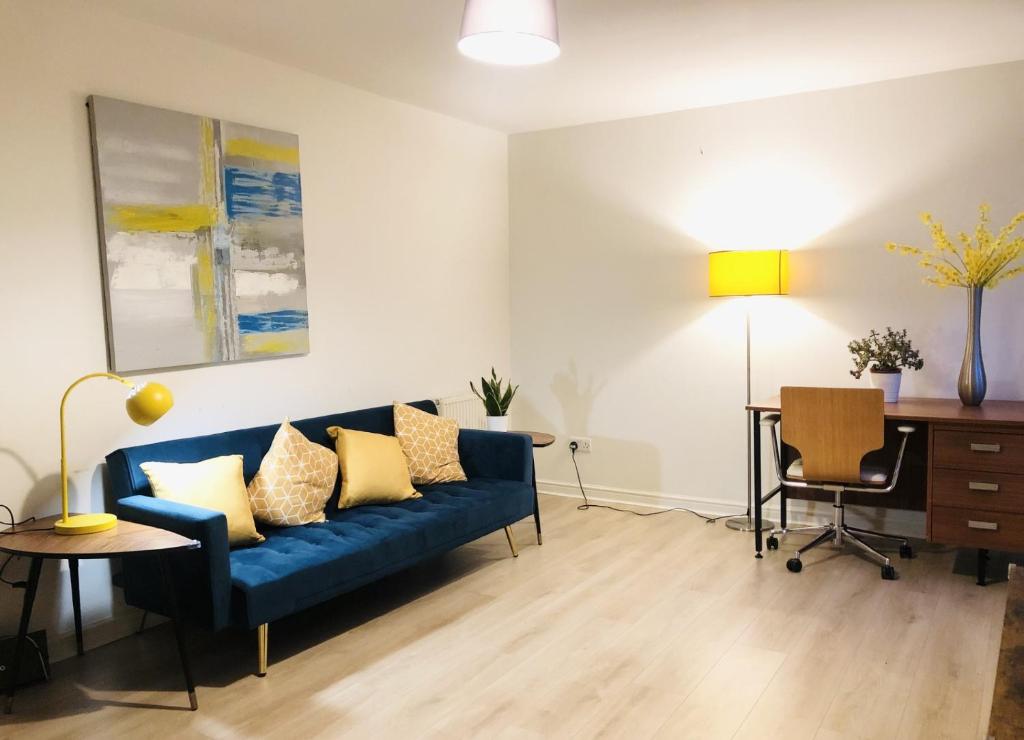 sala de estar con sofá azul y escritorio en Spacious City Centre flat free parking& superfast WIFI, en Edimburgo