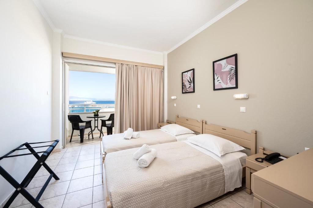 a hotel room with two beds and a view of the ocean at Zephyros Hotel in Kos