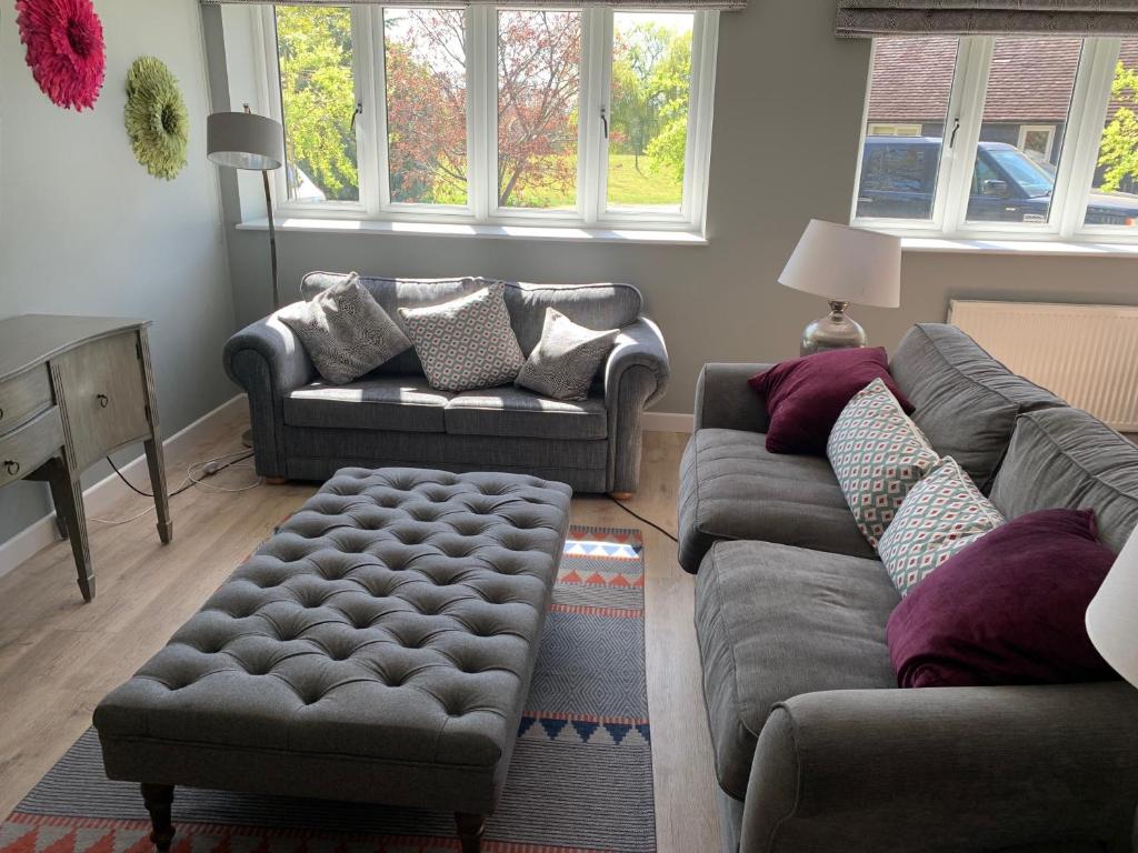ein Wohnzimmer mit 2 Sofas und einem Stuhl in der Unterkunft The Coach House in Warnham