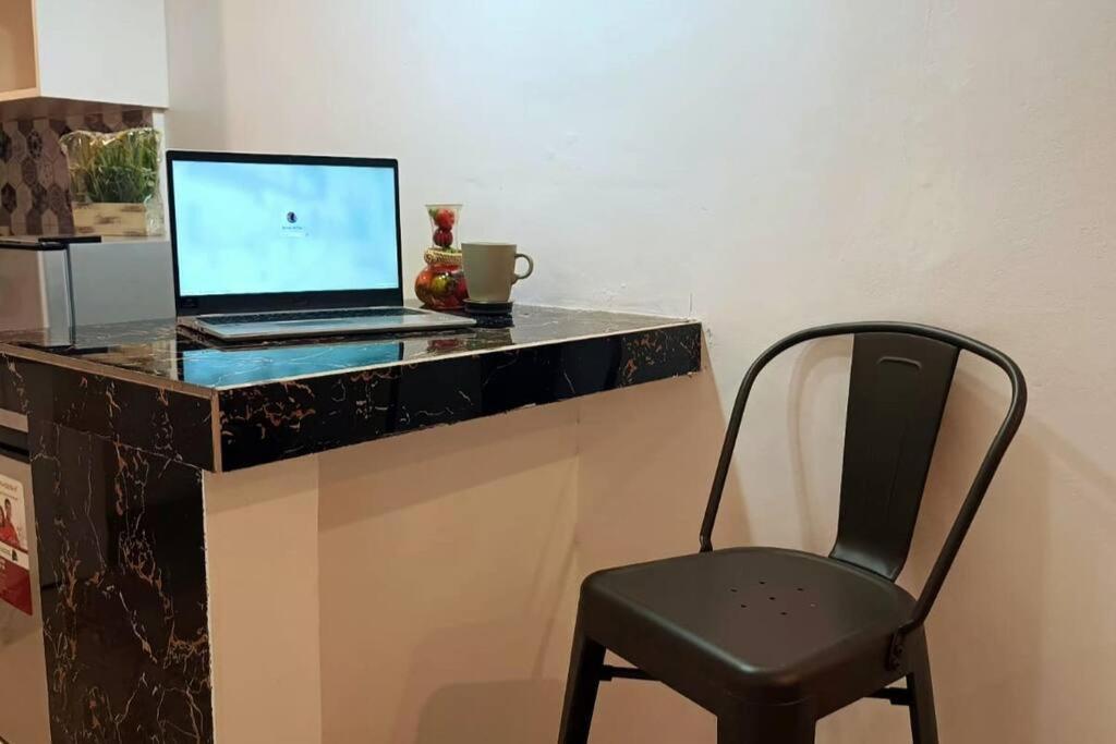 a black desk with a laptop and a chair at Bacolod City's Secret Oasis 