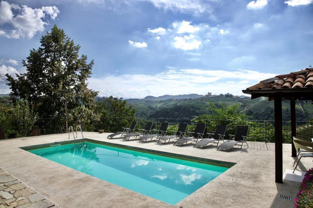 einen Pool mit Stühlen und einem Pavillon in der Unterkunft Villa La Gioiosa in Montelupo Albese