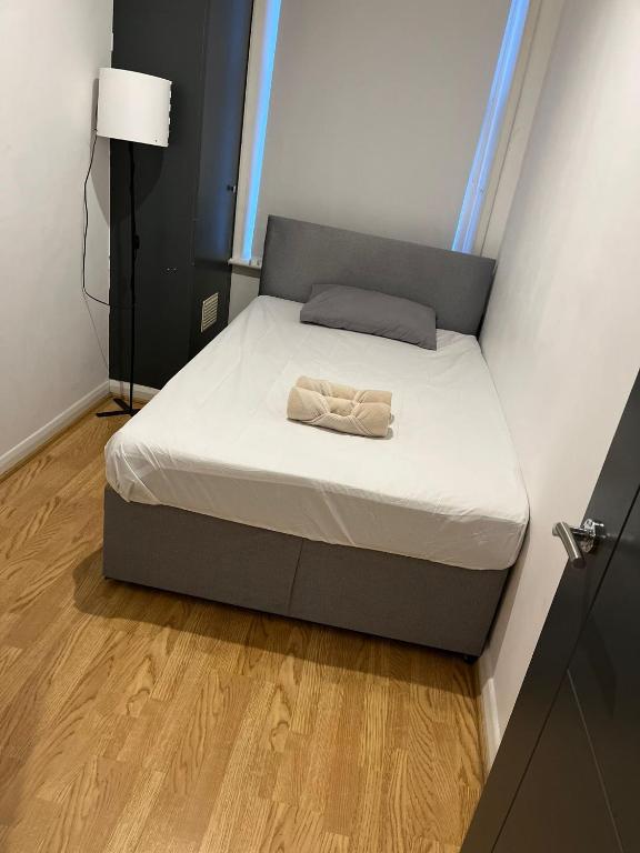 a bed in a small room with a white mattress at Property minutes from Hammersmith and Kensington 2 in London