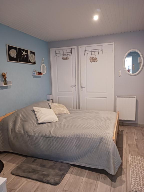 um quarto com uma cama grande e duas portas em Entre terre et mer em Gémozac