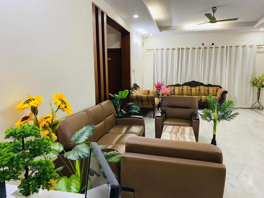 a living room with couches and a couch and plants at KP Suites Gachibowli in Hyderabad