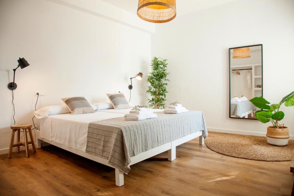 ein weißes Schlafzimmer mit einem großen Bett und einem Spiegel in der Unterkunft FINCA LA CAÑADA SANTA POLA -Villas con piscina privada- in Santa Pola