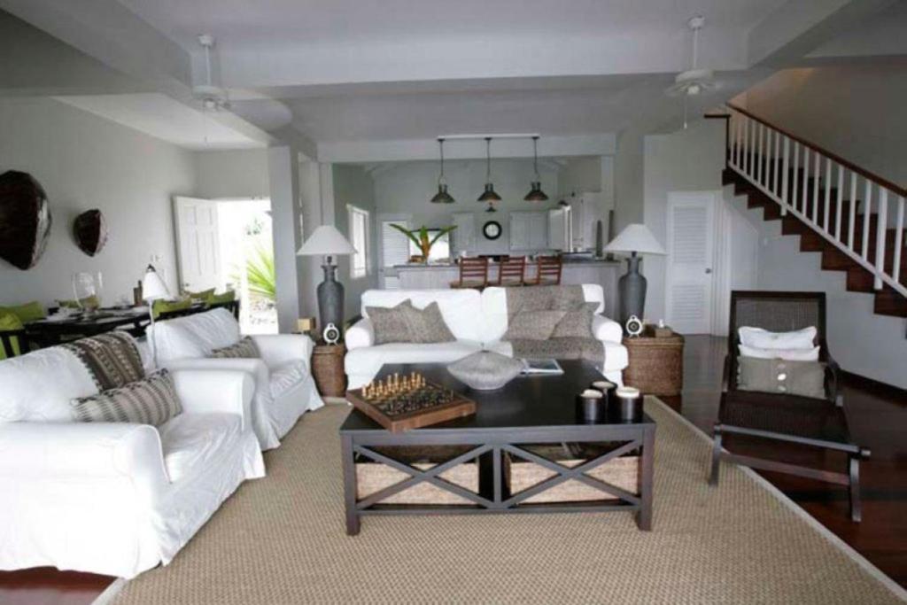 a living room with a white couch and a table at Beautiful 3 BR Villa in Cap Estate in Cap Estate