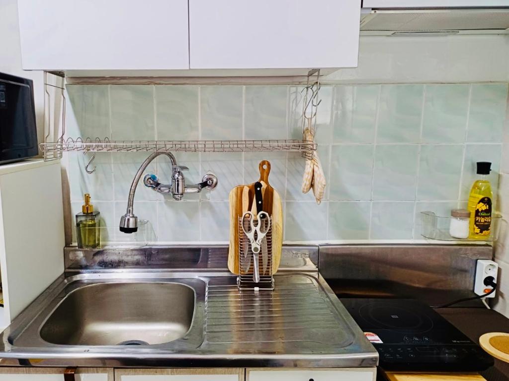a kitchen counter with a sink and a sink at With us house in Ansan