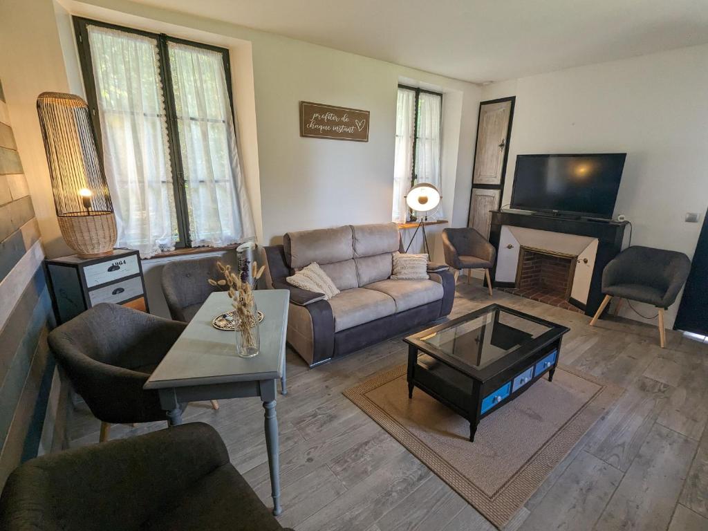 uma sala de estar com um sofá e uma mesa em Gîte Château-Renard, 4 pièces, 6 personnes - FR-1-590-422 em Château-Renard