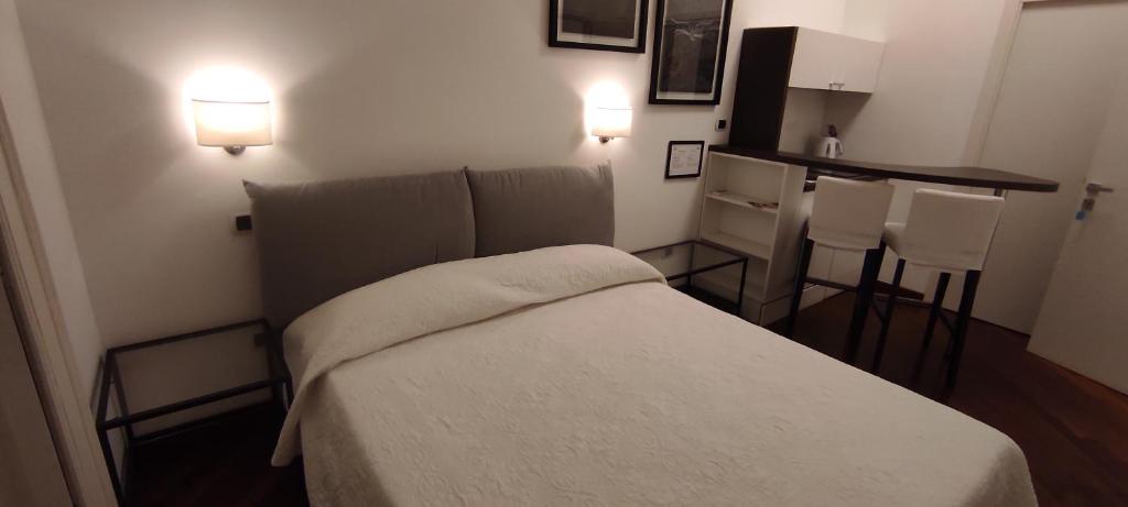 um quarto com uma cama e uma cozinha com duas luzes em Luca Giordano 142 B&B em Nápoles