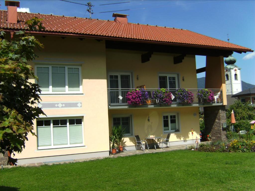 una casa con un balcón con flores. en Ferienwohnung Millonigg, en Vorderberg