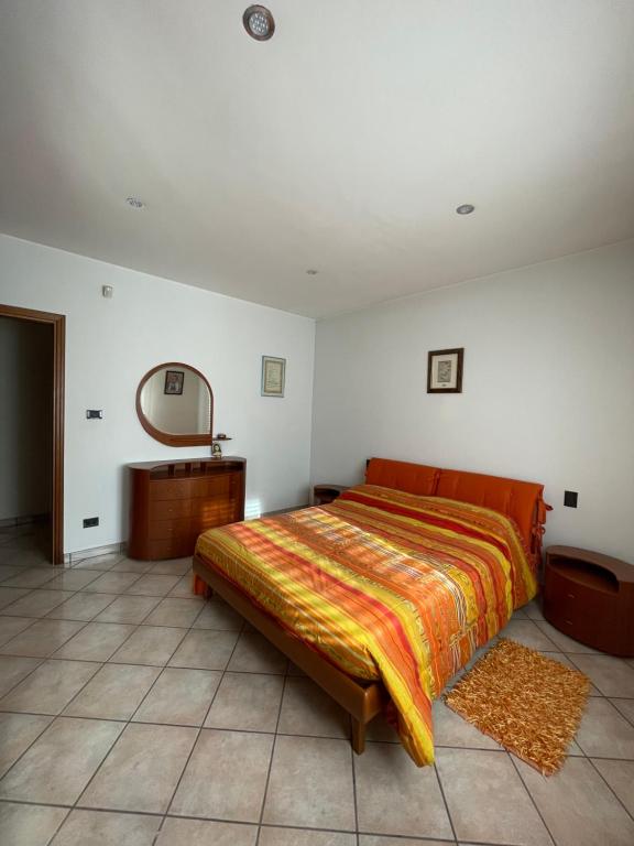 1 dormitorio con 1 cama grande y espejo en La casa di Chloe, en Torrevecchia Teatina