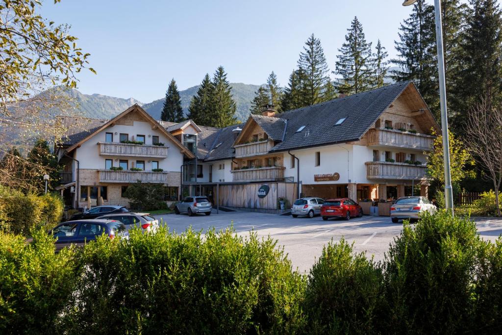 a large building with cars parked in a parking lot at Art Hotel Kristal in Bohinj