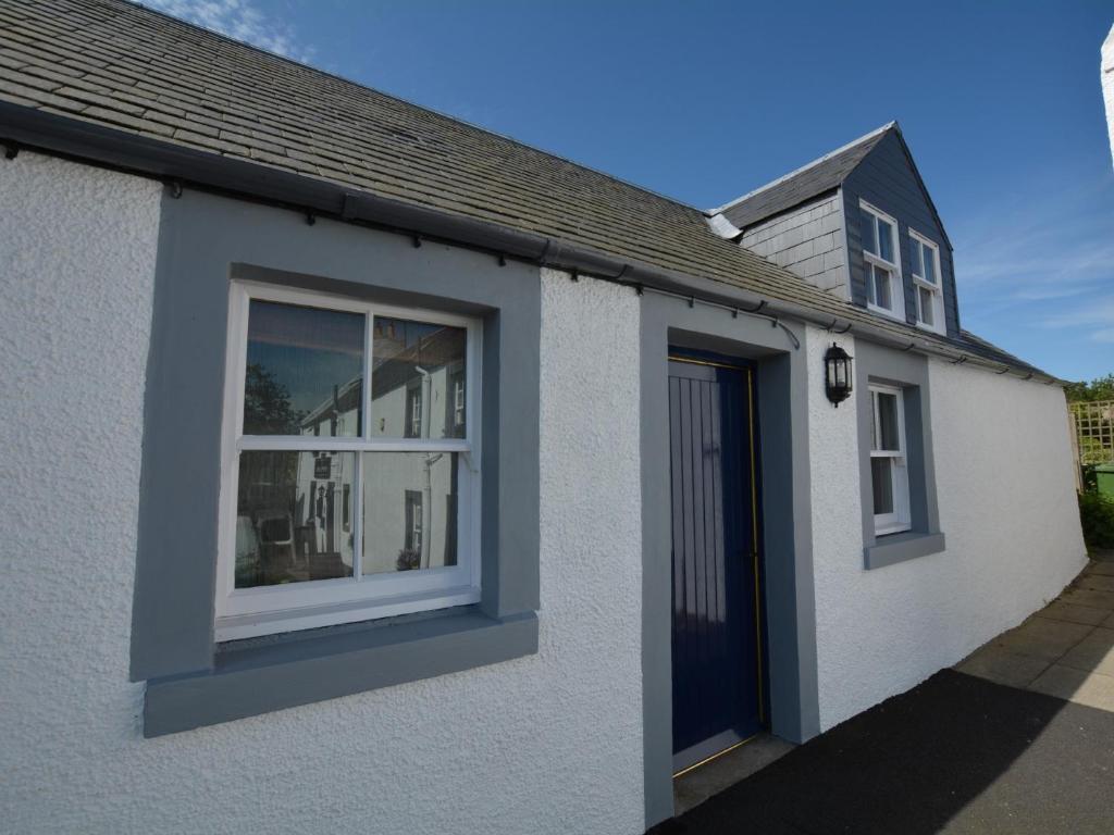 een wit huis met een raam en een blauwe deur bij 1 Bed in Morebattle 52538 in Morebattle
