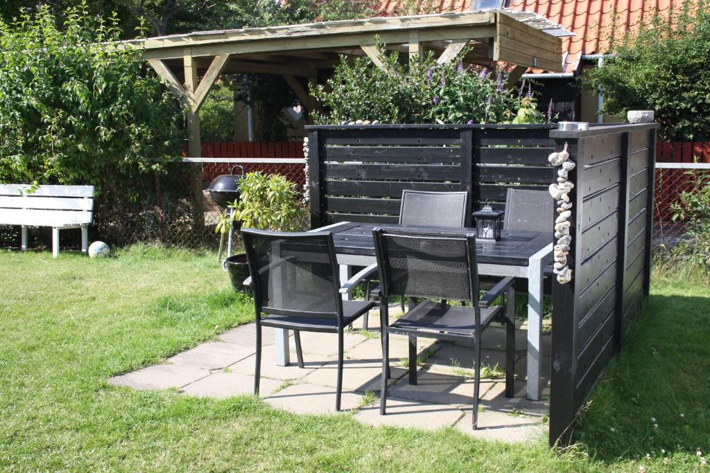 a black table and chairs in a garden at Holiday-Skagen in Skagen