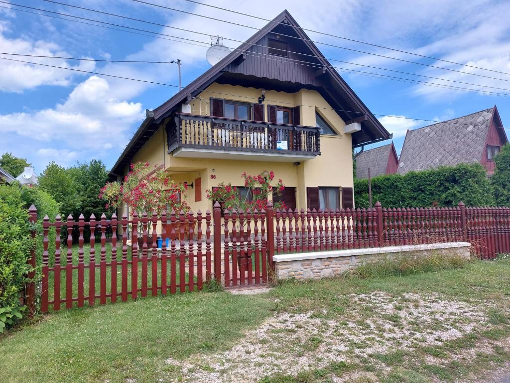 a house with a red fence in front of it at Hanol Apartmanház Balatonlelle in Balatonlelle