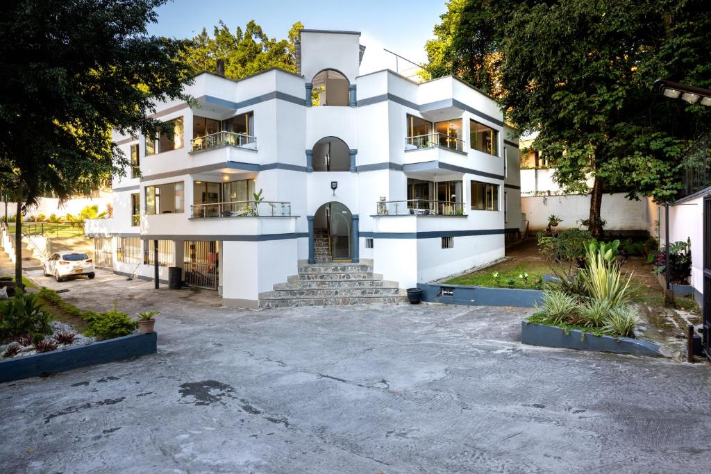 un edificio blanco con una entrada delante de él en El Poblado, La Frontera (Apartamentos), en Medellín