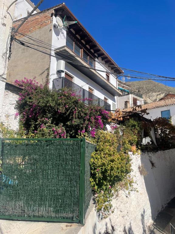 a building with flowers on the side of it at Río Genil in Pinos Genil