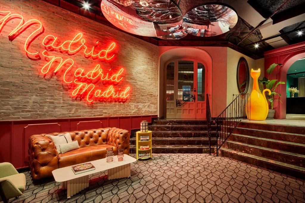 a room with a couch and a neon sign at Avani Alonso Martinez Madrid hotel -previously NH Alonso Martinez in Madrid