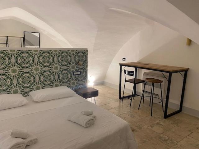 a bedroom with a bed and a table and chairs at Appartamento Pepe in Francavilla Fontana