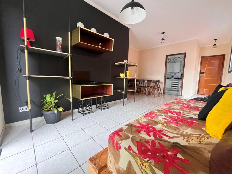 a room with a bed and a living room at Made in Roça in Uberlândia