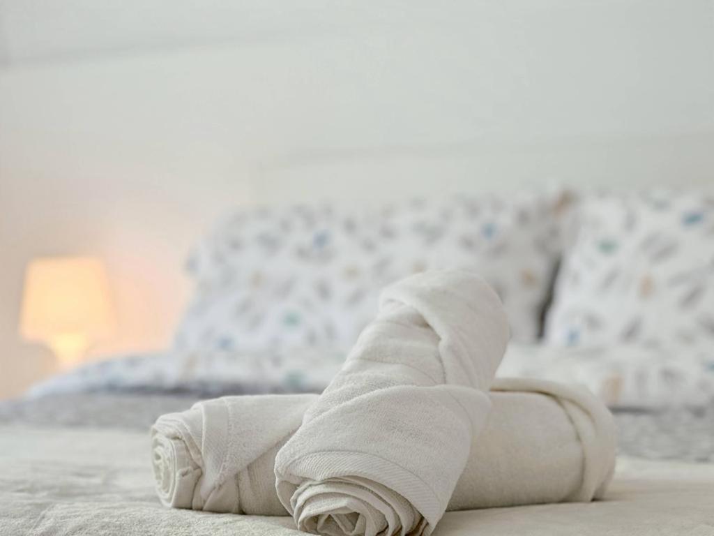 ein rollendes weißes Handtuch auf einem Bett in der Unterkunft Oasis Suite in Avila