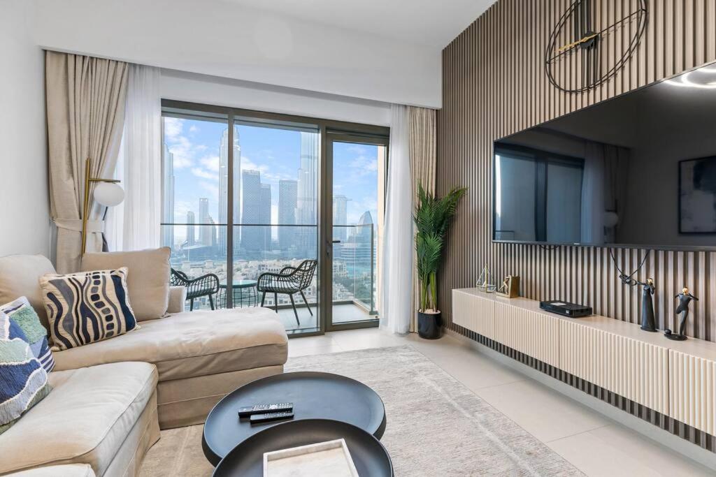 a living room with a couch and a tv at Keysplease Beautiful 2BR Burj Khalifa View, Burj Royale Downtown in Dubai