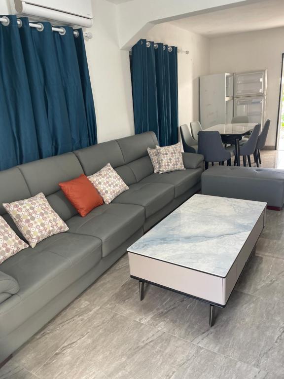 uma sala de estar com um sofá e uma mesa em sunny apartment em Koolbaai