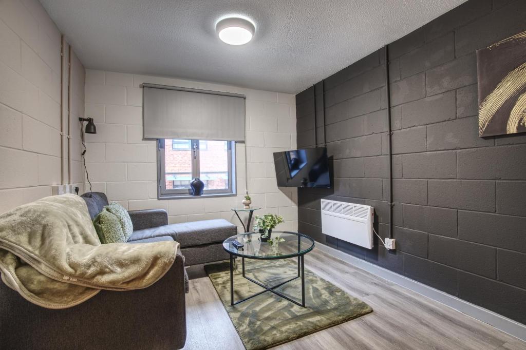 シェフィールドにある#71 Phoenix Court By DerBnB, Industrial Chic 1 Bedroom Apartment, Wi-Fi, Netflix & Within Walking Distance Of The City Centreのリビングルーム(ソファ、テーブル付)