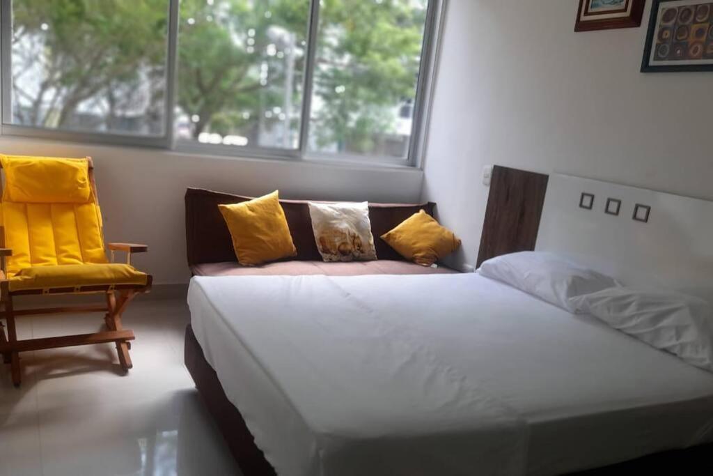 um quarto com uma cama, uma cadeira e janelas em Apartamento en Ricaurte (Peña Azul La Morada) em Ricaurte