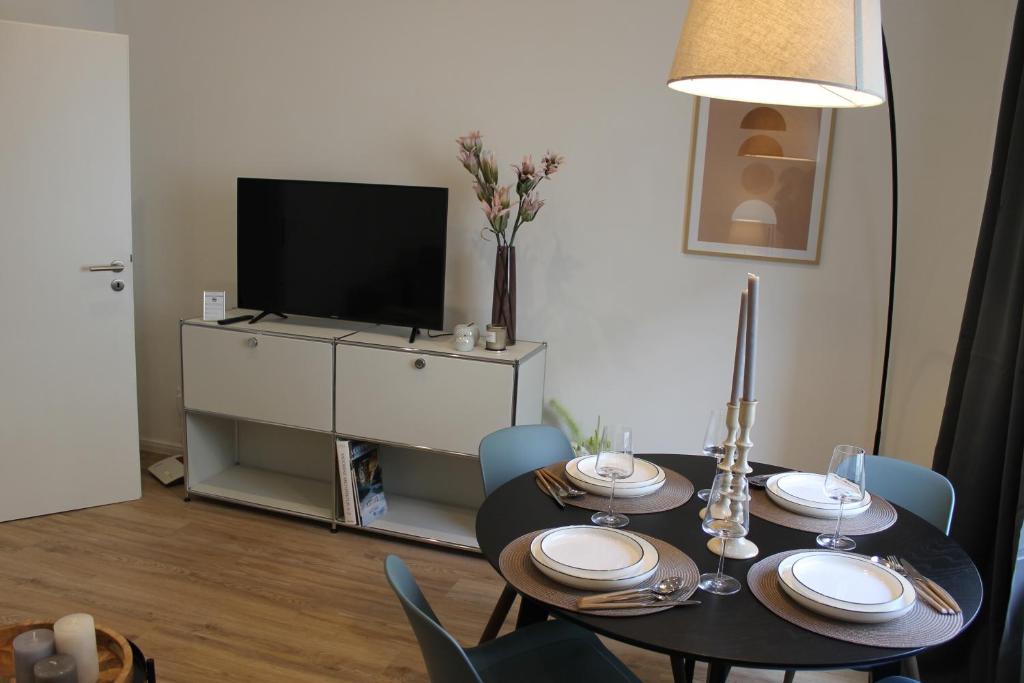 uma sala de jantar com uma mesa e uma televisão em Boutique Apartment im Zentrum em Paderborn