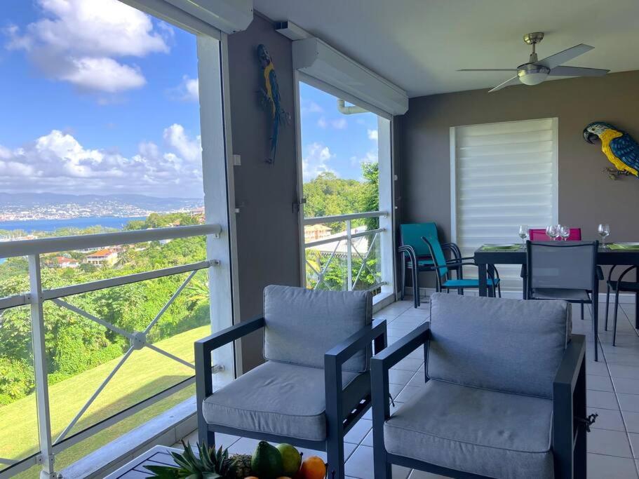 a balcony with chairs and a view of the ocean at Orchidée, Spacieux & Vue mer in Les Trois-Îlets