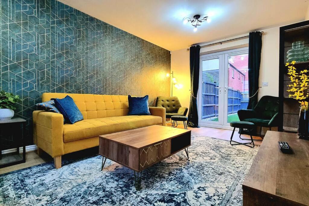 ein Wohnzimmer mit einem gelben Sofa und einem Tisch in der Unterkunft Spacious Modern House with Great Transport Links and Long Stay Discounts in Thurcaston