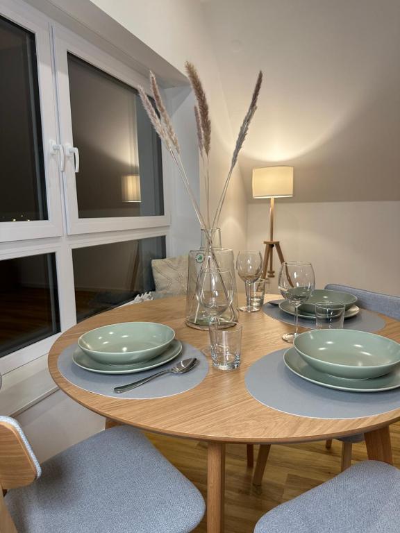 una mesa de comedor con platos y vasos. en Dümmerland Apartments en Lemförde