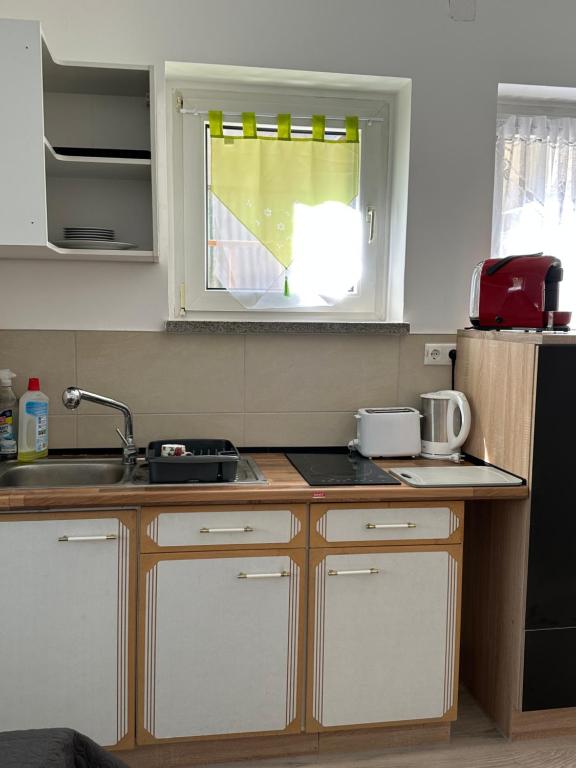 a kitchen with a counter and a sink and a window at Ein Zimmer Wohnung am Markt in Oelsnitz