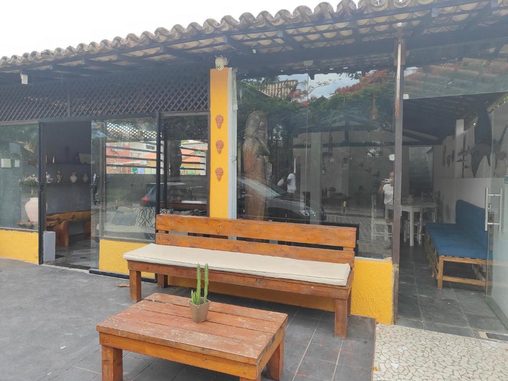 un banco y una mesa frente a una tienda en Pousada Bellas Artes en Mata de Sao Joao