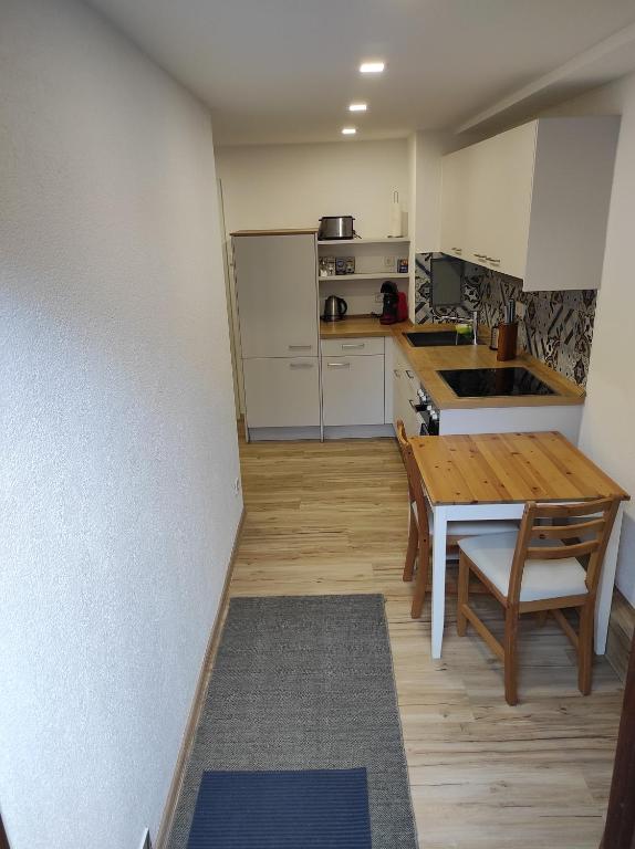 eine kleine Küche mit einem Holztisch und einem Tisch mit Stühlen in der Unterkunft TinyFeWo Markdorf in Markdorf