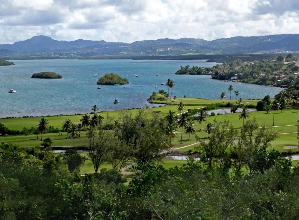 a view of a large body of water with islands at Orchidée, Spacieux & Vue mer in Les Trois-Îlets