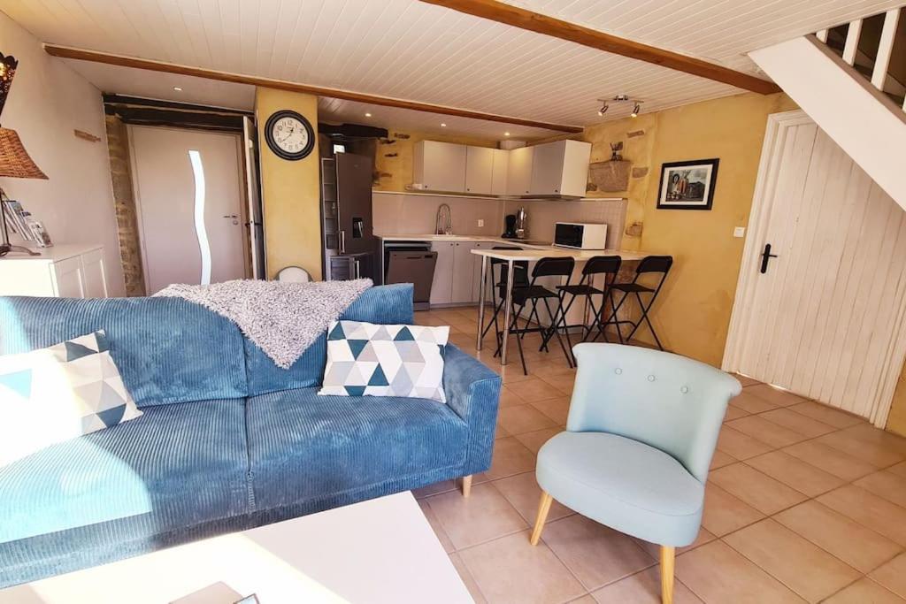 un salon avec un canapé bleu et une cuisine dans l'établissement Les gîtes du Kokopelli : Maupiti, à Plumelec