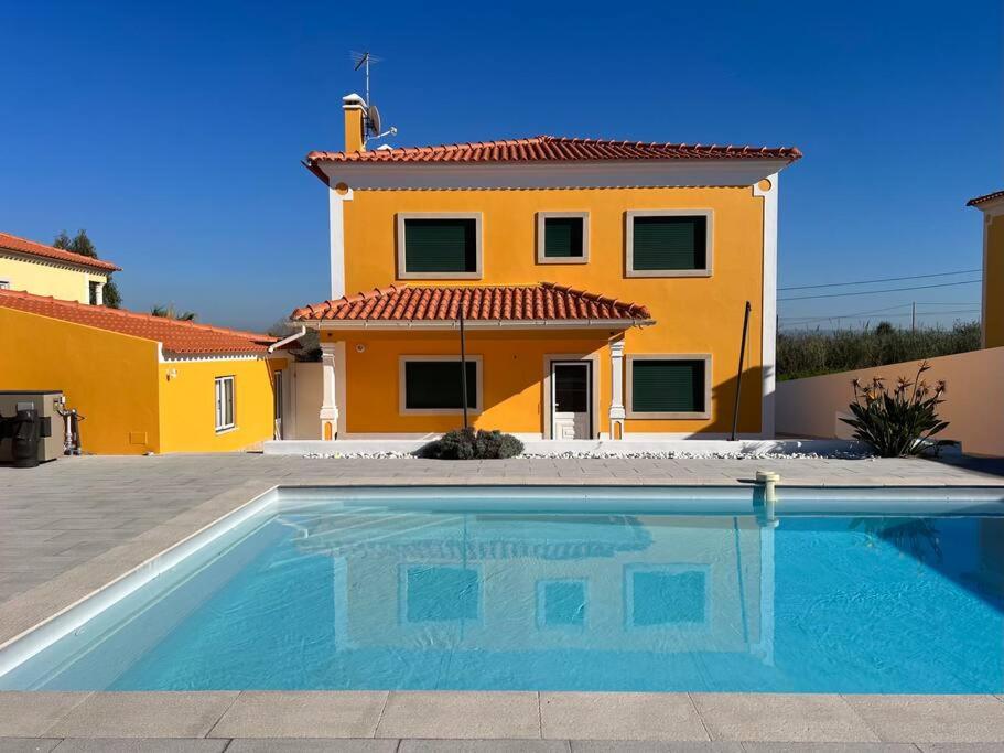 a house with a swimming pool in front of a house at La villa du Paradis du Coto - Piscine-Mer&Surf in Coto