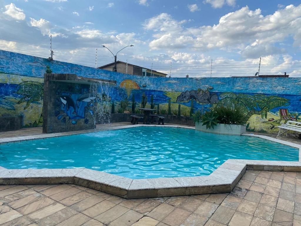 阿拉皮拉卡的住宿－CONFORT HOTEL ARAPIRACA，壁画前的游泳池