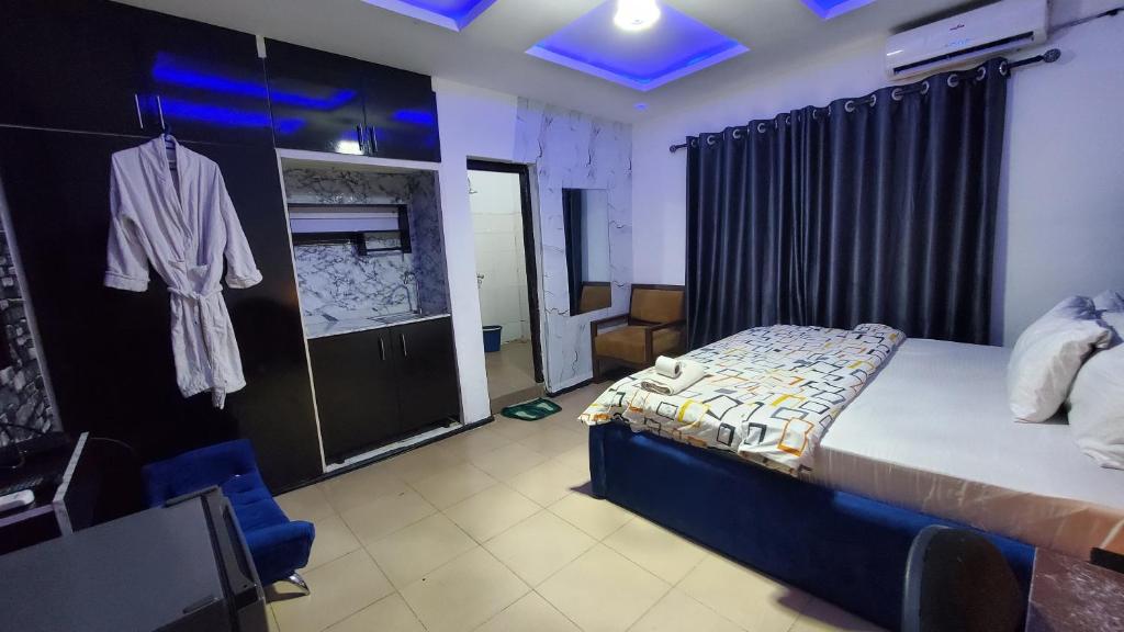 a bedroom with a bed and a robe hanging on a wall at Weltons Apartments in Ikeja