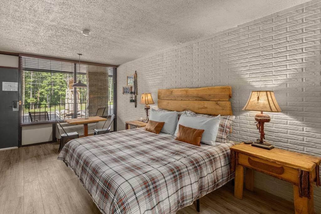 1 dormitorio con 1 cama y 1 mesa con lámpara en Stonegate Lodge King Bed Fast WiFi 50in Roku TV Salt Water Pool Room # 304, en Eureka Springs
