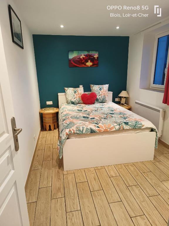 une chambre avec un lit et un mur bleu dans l'établissement Appartement avec Terrasse, à Blois